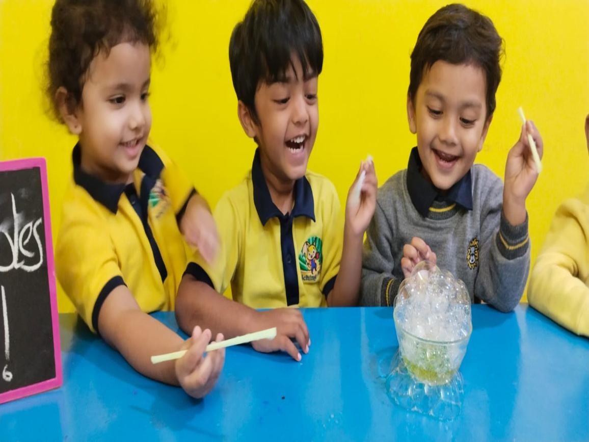 Children enjoying a hands-on classroom experiment at Enriching Minds